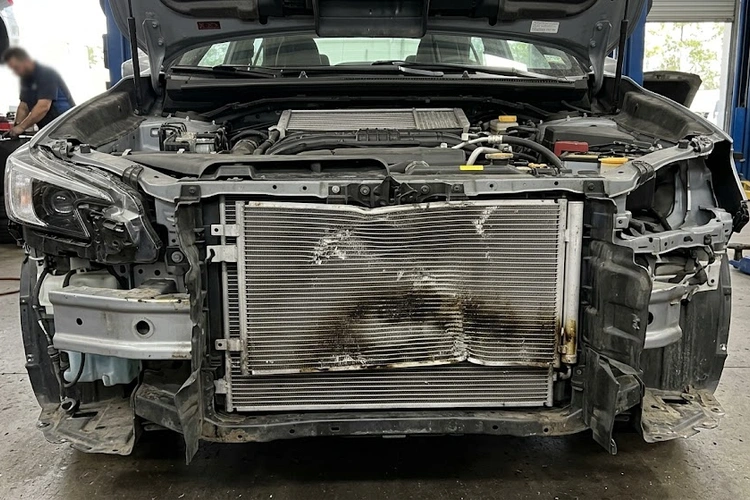 bad ac condenser symptoms showing bent fins and refrigerant oil stains on a damaged condenser