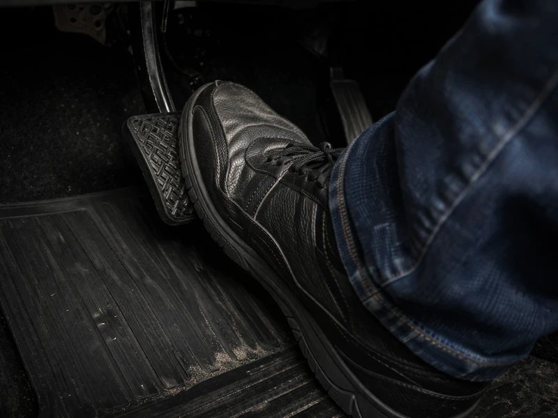 brake pedal goes to floor — mechanic inspecting brake caliper and hydraulic line