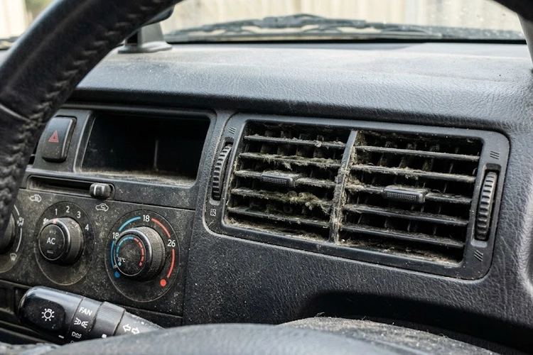 Car AC evaporator coil with mold buildup causing musty smell inside cabin