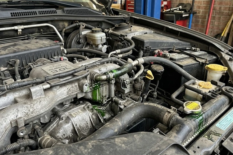 mechanic inspecting coolant hoses after noticing car smells like maple syrup