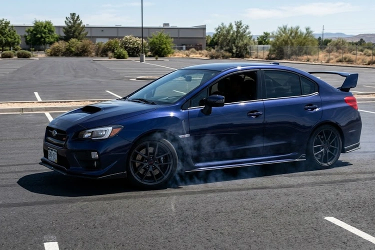 Mechanic performing brake pad break-in procedure on a car rotor — how to break in new brake pads