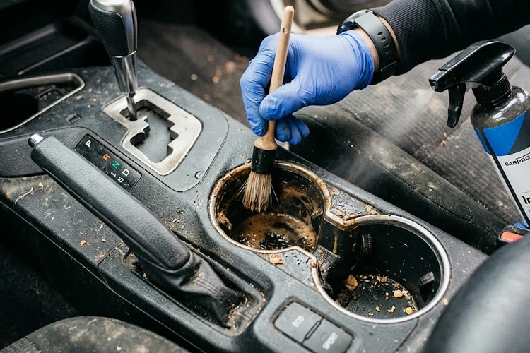 how to clean car cup holders using a detailing brush and microfiber cloth