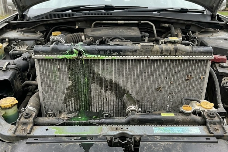 Close-up of a car radiator showing coolant deposits and corrosion — radiator leaking symptoms