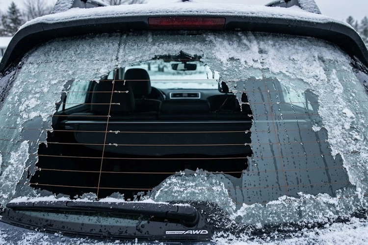 rear defrost not working — close-up of rear window heating grid lines with frost on glass