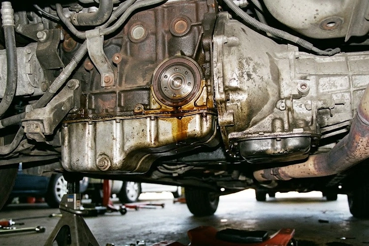rear main seal leak symptoms visible as oil accumulation on transmission bell housing