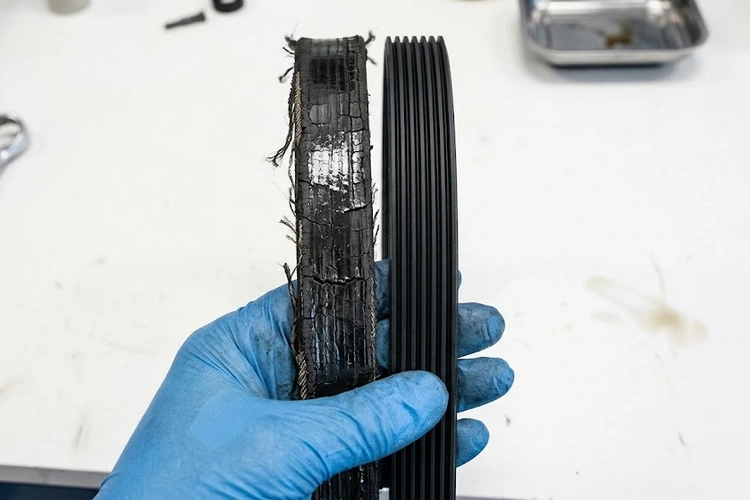 Close-up of a worn serpentine belt showing lateral cracking and glazing — classic serpentine belt symptoms